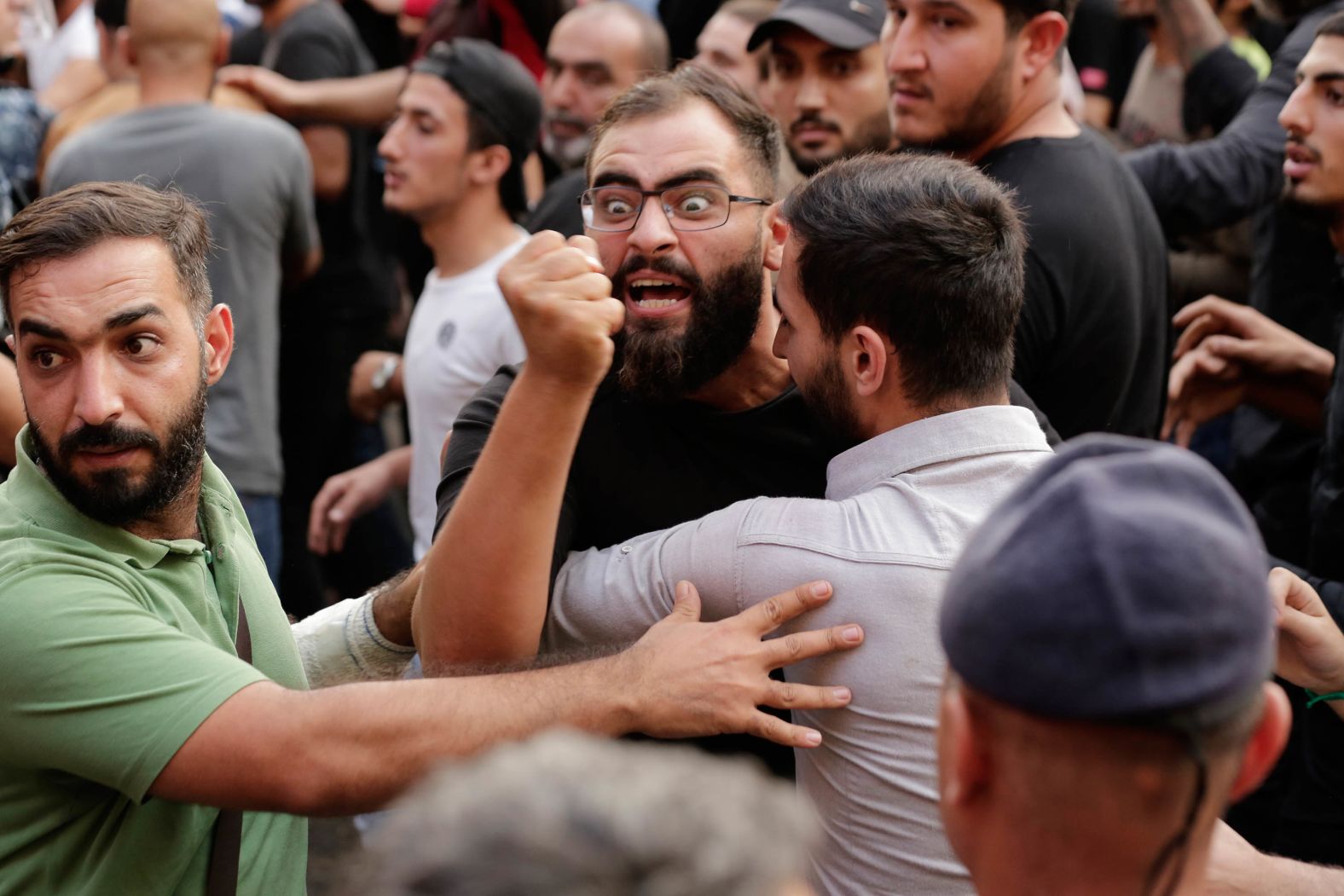 Anti-government protesters and Hezbollah supporters clash on Friday, October 25.