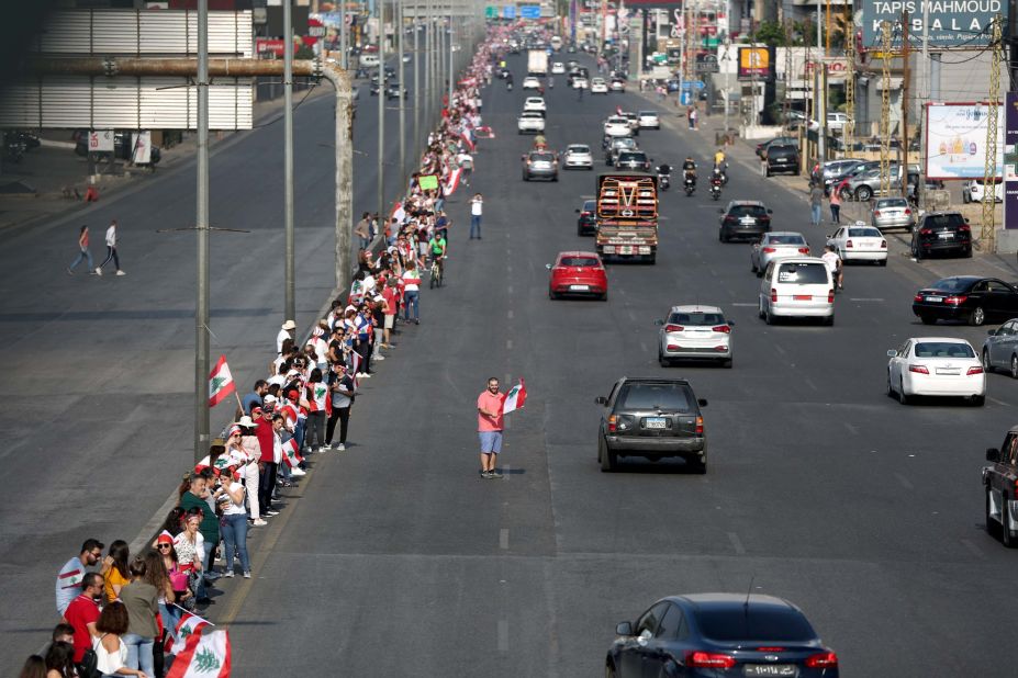 Protesters hold hands to form a human chain along a coastal highway near Beirut on Sunday, October 27.