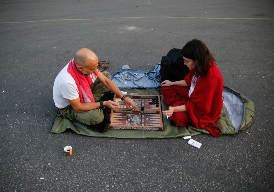 Anti-government protesters play a dice game as they block a main highway during during demonstrations.