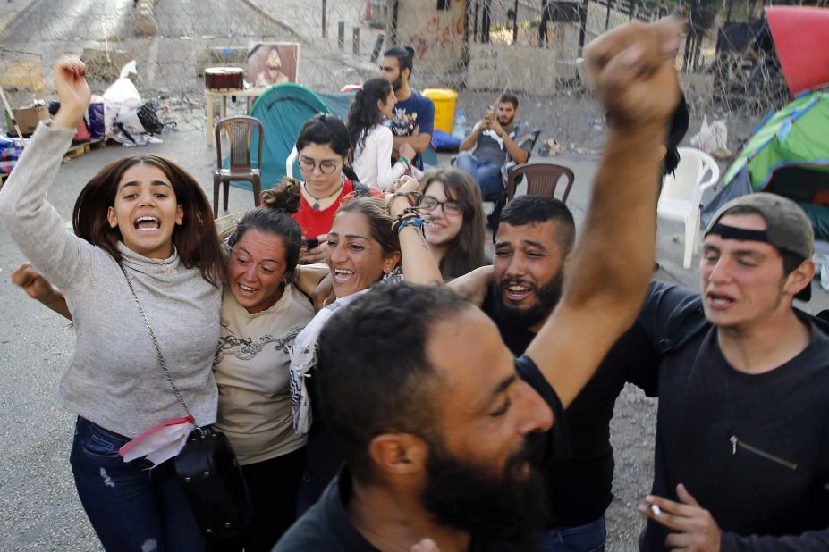 Anti-government protesters celebrate outside the government palace after Hariri announced his resignation.