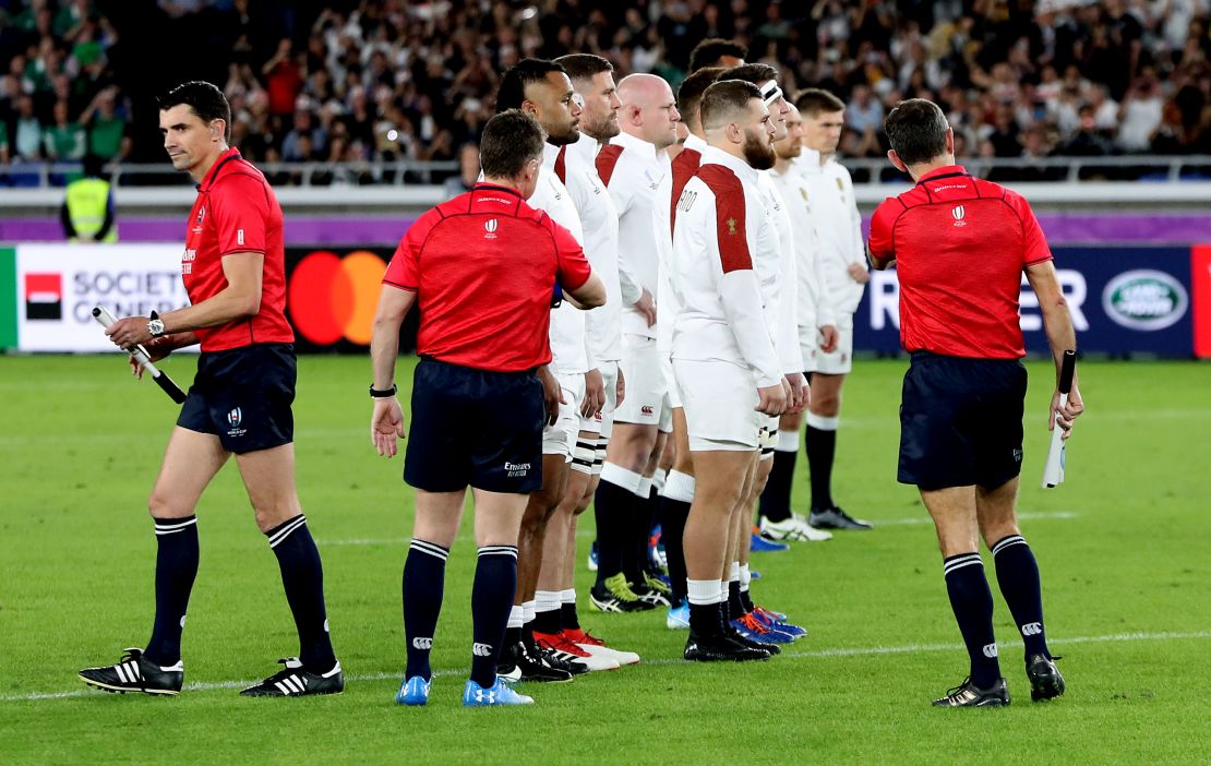 Nigel Owens, the referee, attempts to pull back the England team as they face the New Zealand haka.