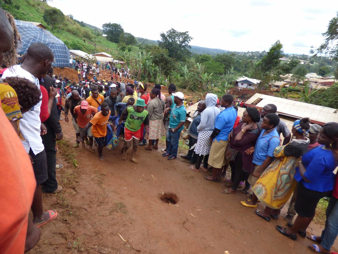 Rescue workers carry a body from the rubble of the landslide in Bafoussam 