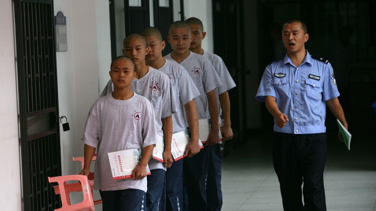 A policeman leads inmates to attend a class at the Chongqing Juvenile Offender Correctional Center. Minors who commit serious offenses can be sent to rehabilitation centers like this one.