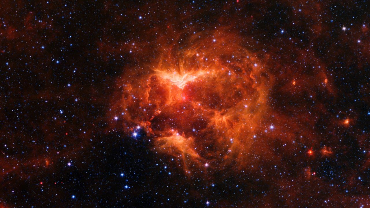 The Jack-o'-lantern Nebula is on the edge of the Milky Way. Radiation from the massive star at its center created spooky-looking gaps in the nebula that make it look like a carved pumpkin.