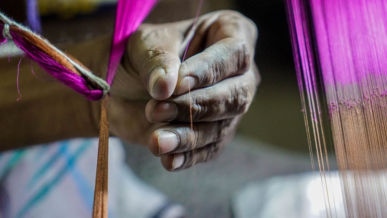 Master silk weaver Ranzan Ali ties together each individual thread to the handloom from his workshop in Varanasi. 