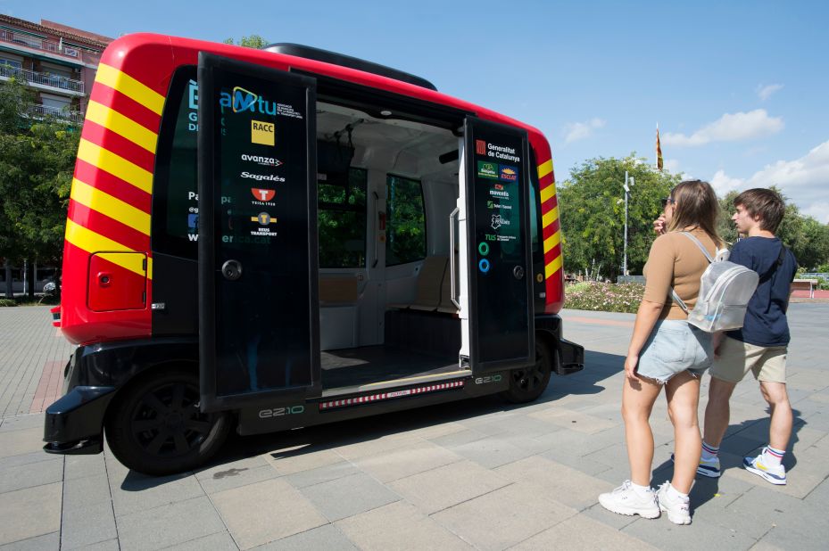 Tourists looking at "Erica", the first driverless autonomous bus in Catalonia, during its presentation in 2018. 