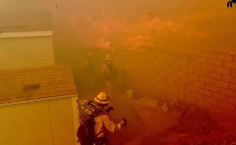 Flames approach the backyards of mobile homes in Jurupa Valley, California, on October 30.