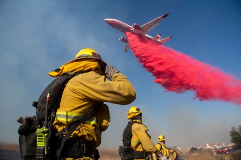Firefighters brace themselves for incoming fire retardant as they battle the Easy Fire in Simi Valley.