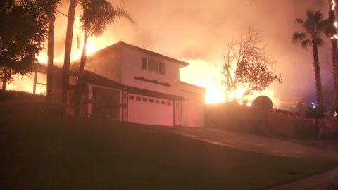 The Hillside Fire burns early Thursday just behind a home in northern San Bernardino.