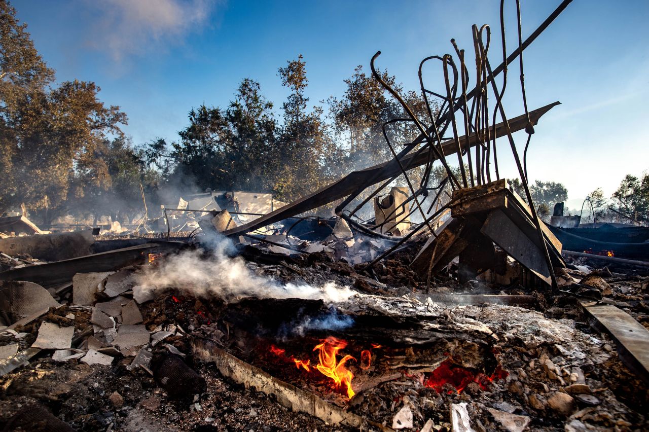 The remains of the Louis Robidoux Nature Center keep smoldering after the structure was destroyed by a wildfire in Riverside, California.
