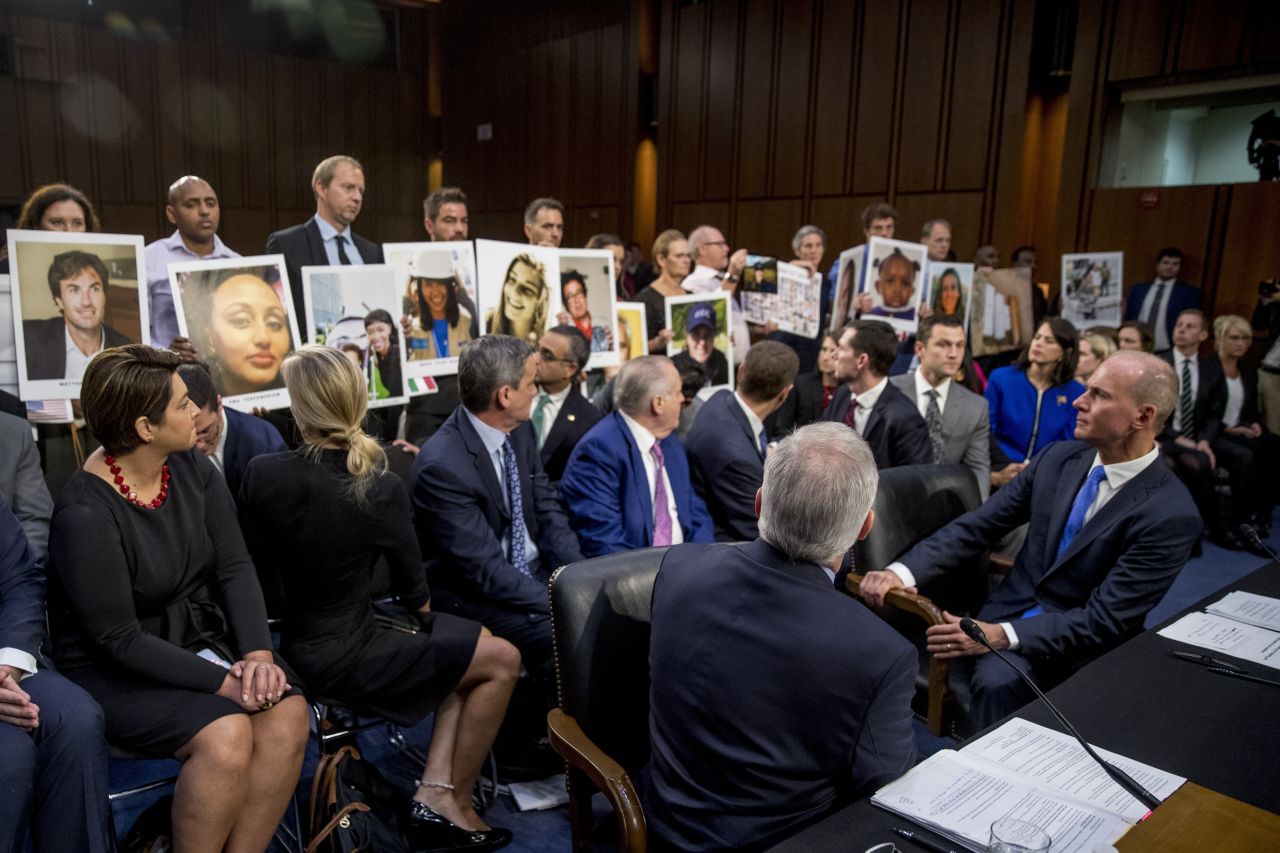 Boeing CEO Dennis Muilenburg, bottom right, watches as people hold up photos of plane crash victims on Tuesday, October 29. <a href="https://www.cnn.com/2019/10/29/politics/boeing-hearing-737-max/index.html" target="_blank">Muilenburg admitted to Congress that his company made mistakes</a> with the design of its 737 MAX jet and deserves the scrutiny it is receiving after two fatal crashes. 