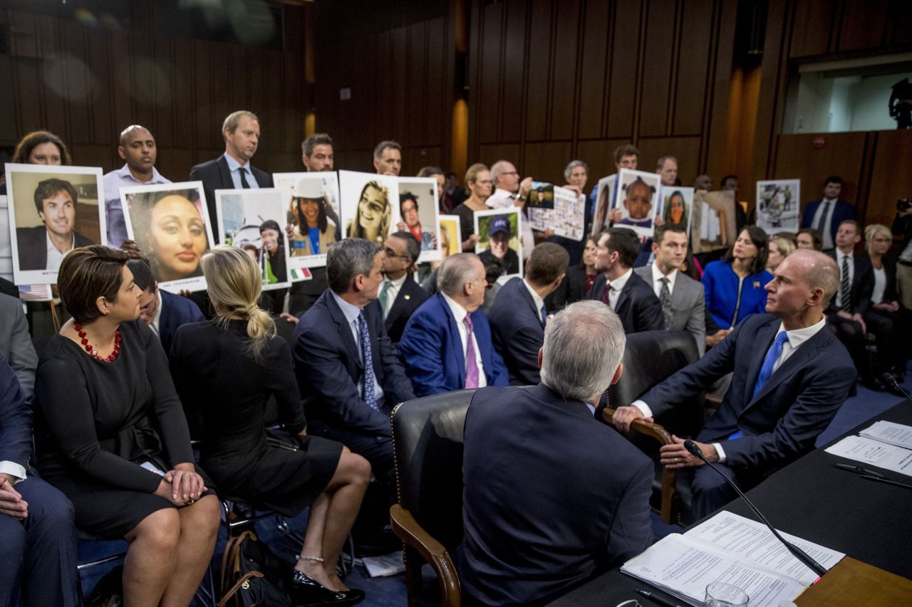 Boeing CEO Dennis Muilenburg, bottom right, watches as people hold up photos of plane crash victims on Tuesday, October 29. <a href="https://www.cnn.com/2019/10/29/politics/boeing-hearing-737-max/index.html" target="_blank">Muilenburg admitted to Congress that his company made mistakes</a> with the design of its 737 MAX jet and deserves the scrutiny it is receiving after two fatal crashes.