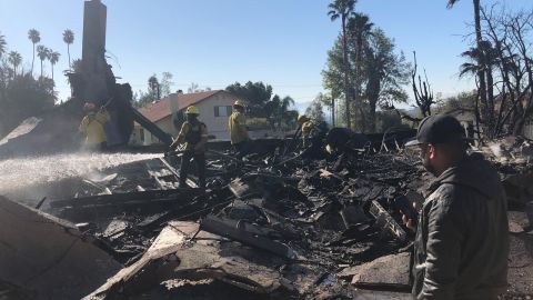 Matthew Valdivia stands in front of the burned wreckage of his house in San Bernardino.