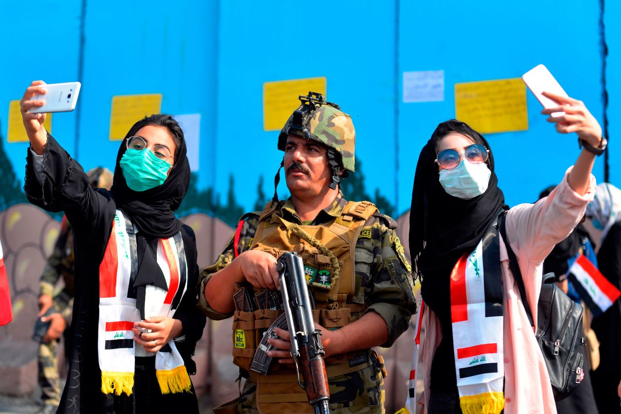 Iraqi students pose for selfies with a member of the country's security forces during anti-government protests in Diwaniyah, Iraq, on Thursday, October 31. Iraqi Prime Minister Adil Abdul Mahdi <a href="https://www.cnn.com/2019/10/31/middleeast/iraq-prime-minister-resigns-intl/index.html" target="_blank">has agreed to resign</a> after weeks of protests that led to hundreds of casualties, Iraq's president announced. The protests, which have gripped parts of Iraq for the past month, were sparked by longstanding complaints over unemployment, government corruption and a lack of basic services such as electricity and clean water.