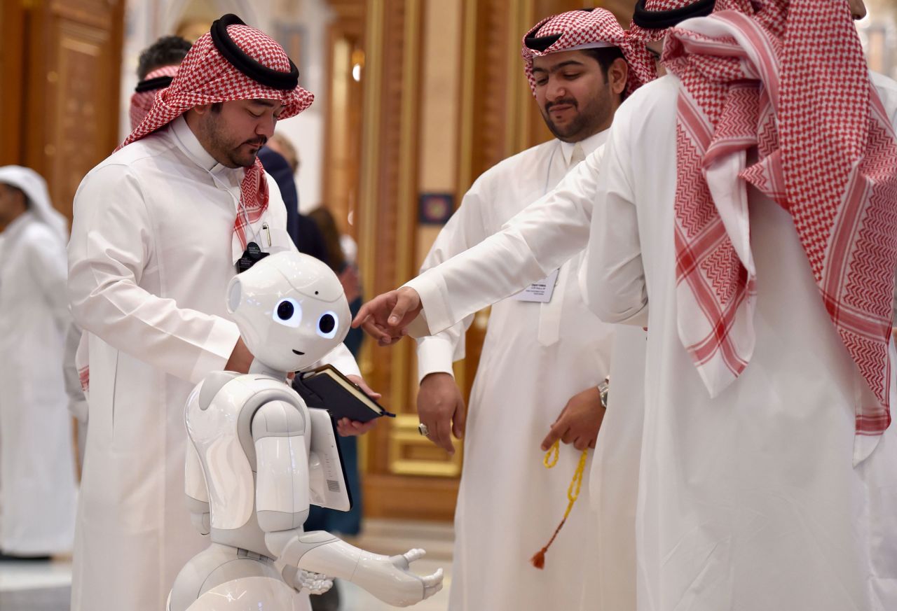 Delegates chat near a robot during the Future Investment Initiative forum in Riyadh, Saudi Arabia, on Wednesday, October 30.