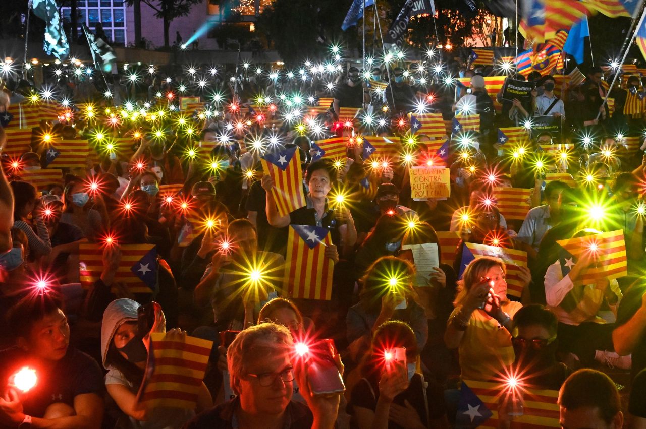 People in Hong Kong hold Catalan pro-independence flags and shine lights from their cell phones during a Hong Kong-Catalonia solidarity rally on Thursday, October 24.