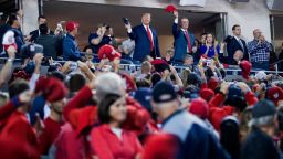 President Donald Trump, center, accompanied by Sen. David Perdue, R-Ga., right, stands as members of the military are recognized during Game 5 of a baseball World Series between the Houston Astros and the Washington Nationals at Nationals Park in Washington, Sunday, Oct. 27, 2019. (AP Photo/Andrew Harnik)