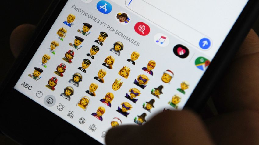 TOPSHOT - A person holds an iPhone showing emojis in Hong Kong, on October 30, 2019. - Apple has put out new gender neutral emojis of most of its people icons -- including punks, clowns and zombies -- as part of an update to its mobile operating system.
The tech giant has offered growing numbers of inclusive designs in recent years, putting out a range of skin tones and occupations, with Google's Android publishing its own non-binary faces in May. (Photo by TENGKU Bahar / AFP) (Photo by TENGKU BAHAR/AFP via Getty Images)