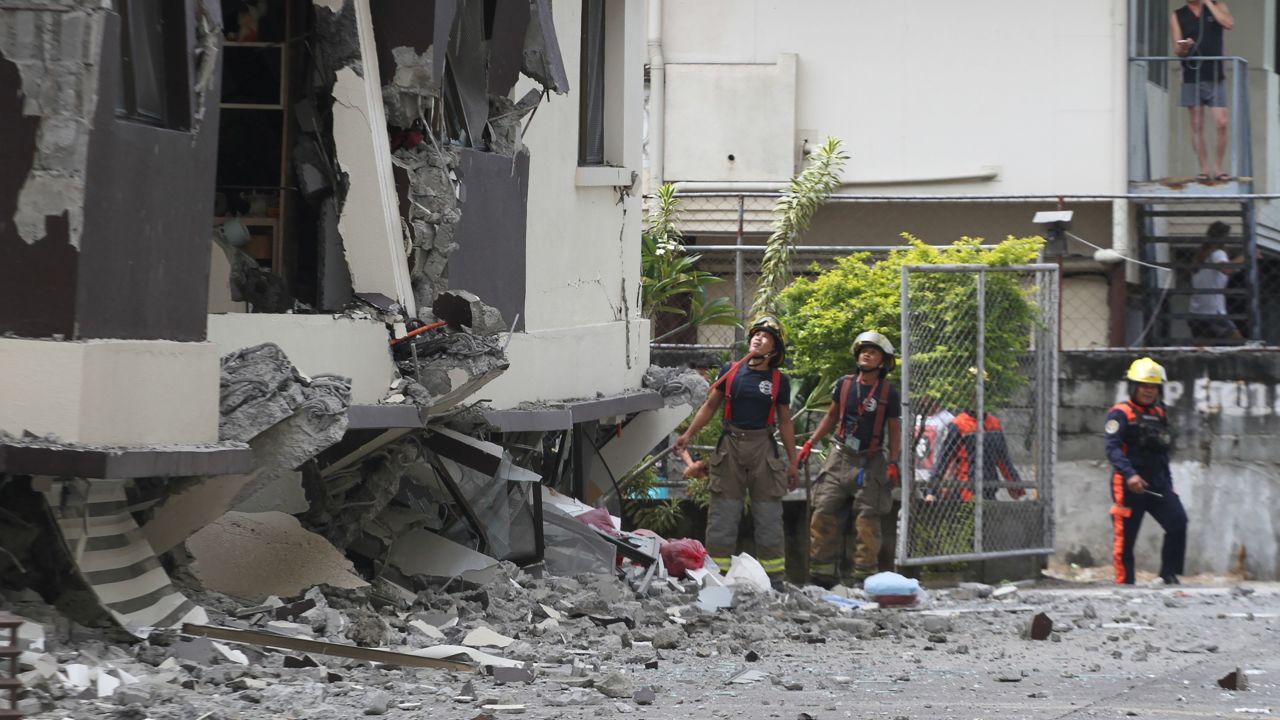 Rescuers look at the damaged condominium building after a 6.5-magnitude earthquake hit Davao City in the southern island of Mindanao on October 31, 2019.