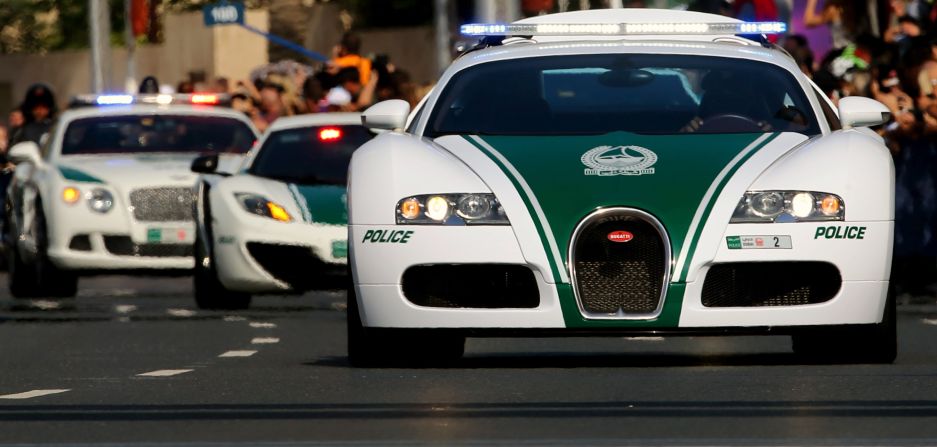 A Dubai police Bugatti leads a convoy of police vehicles including a Lamborghini Aventador and a Bentley as they drive through the streets of downtown Dubai. <br /><br />Such iconic designs are said to be popular tourist attractions, drawing crowds as they patrol the city. 