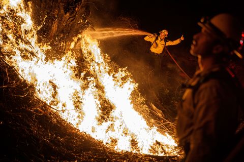 Firefighters spray water on a backfire while battling the spread of the Maria Fire on Friday, November 1. It is just one of the numerous wildfires in California right now.