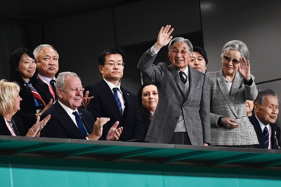 Japan's former Emperor Akihito (centre L) and Empress Michiko wave during the bronze final match.