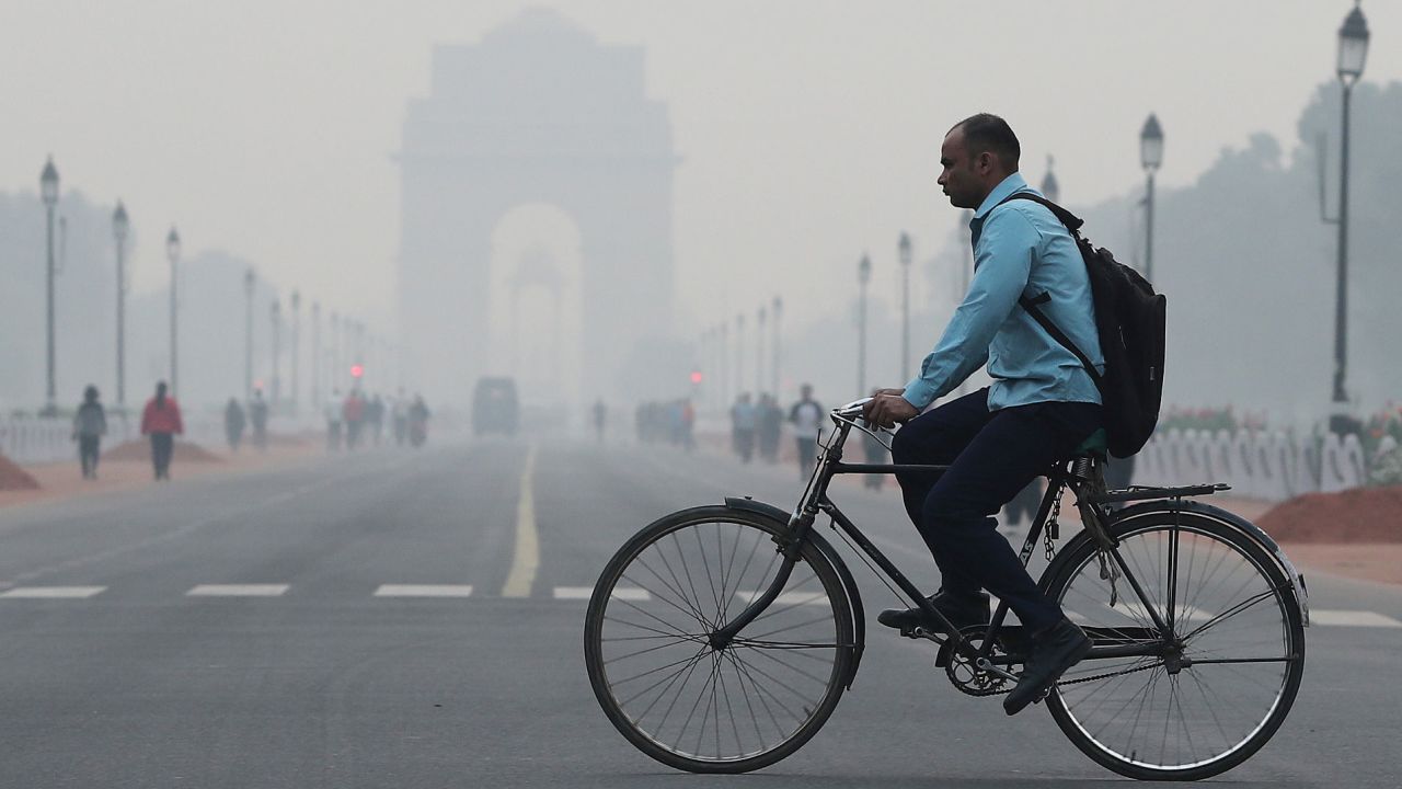 A man cycles through New Delhi amid smoggy conditions in October 2019. 