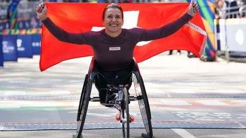 Manuela Schar holds the Swiss flag aloft after winning a third-straight NYC Marathon. 