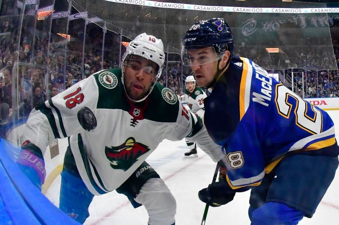 Minnesota's Jordan Greenway and St. Louis' Mackenzie MacEachern fight over the puck at the Enterprise Center in St. Louis, Missouri, on Wednesday, October 30. 