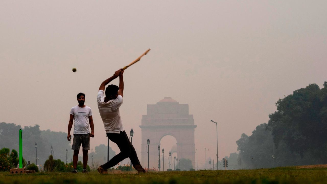 Youths play cricket in a park near India Gate under heavy smog in New Delhi on October 29.