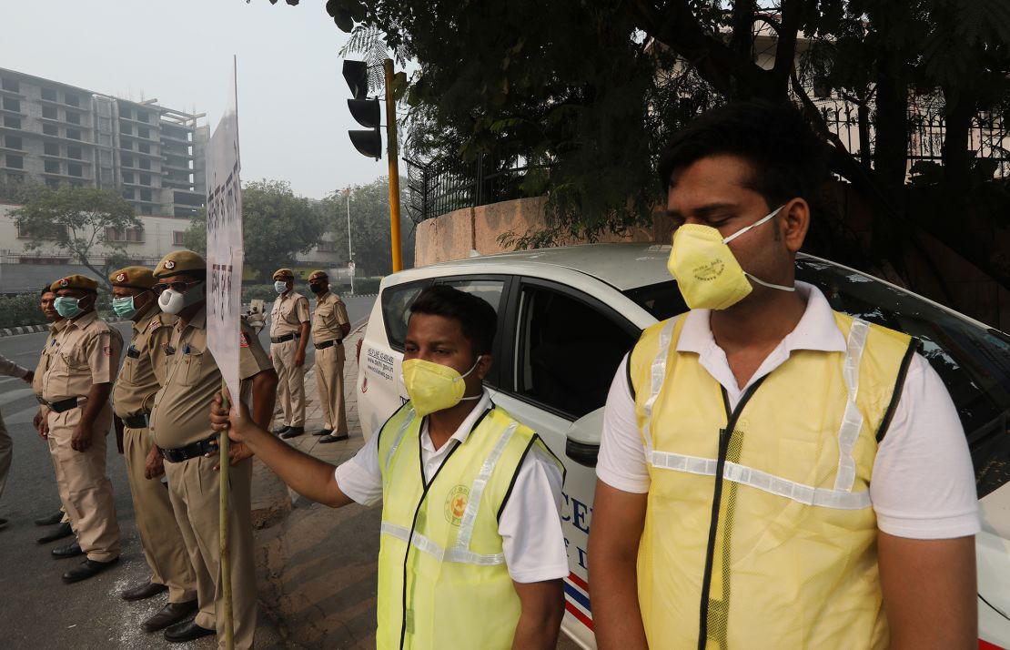 Volunteers and police wearing pollution masks instruct drivers to obey odd and even day rules to help reduce traffic emmisions and smog in New Delhi on Monday, November 4.