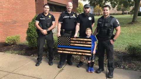 Montgomery County police officers with resident James Shelton and his son, who made the flag for National First Responders Day.