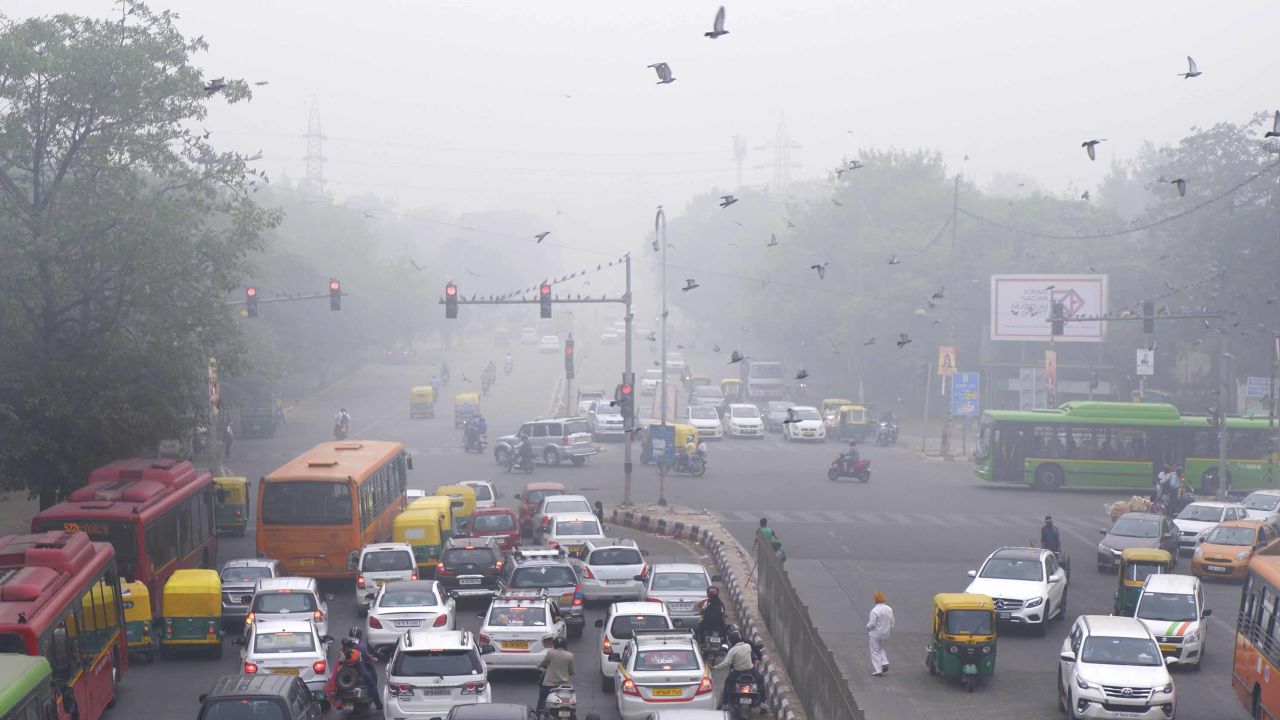 Vehicles wait at a traffic light amid heavy morning smog in New Delhi on Sunday, November 3.