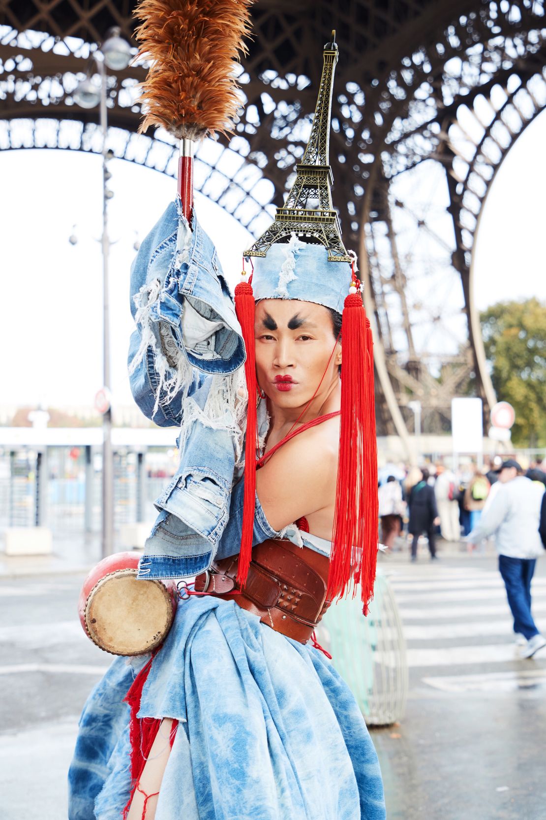 An outfit made of recycled denim, a miniature Eiffel Tower and long, red Chinese tassels.