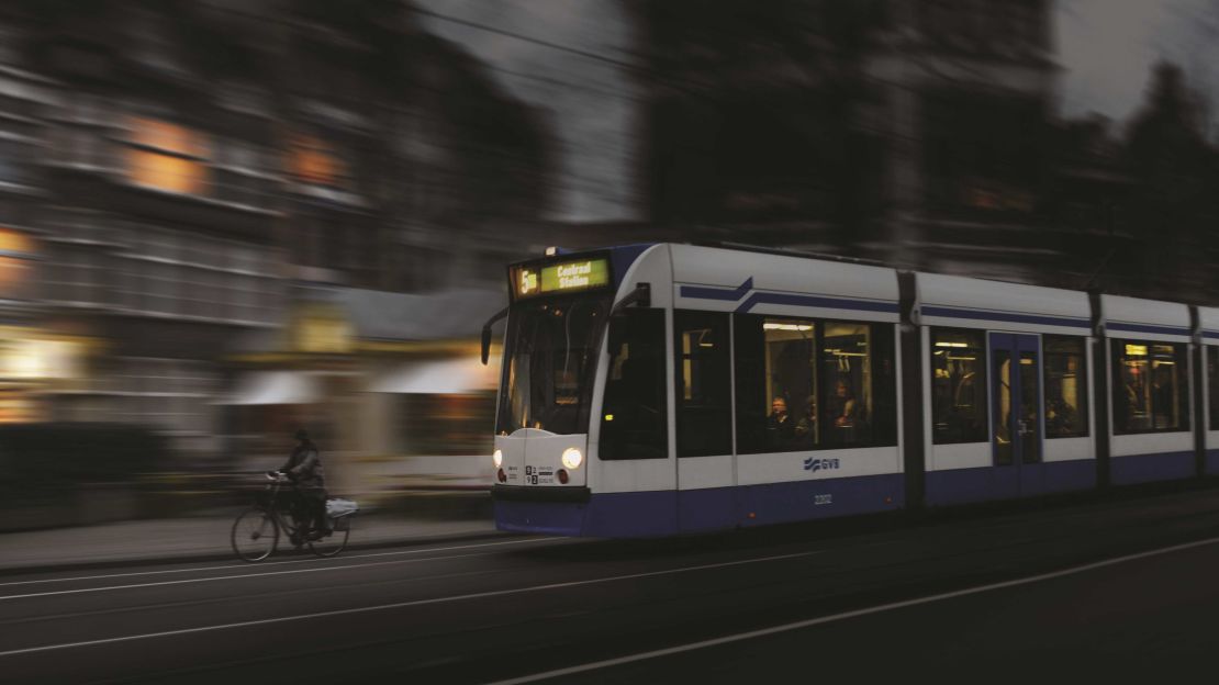 A tram and a bike riding through the streets of Amsterdam in the Netherlands.