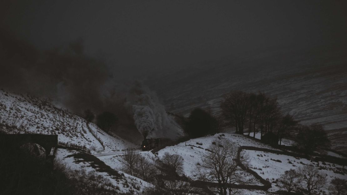 A London Midland and Scottish Railway steam train spotted through the fog at Aisgill, Cumbria in the Lake District in England.