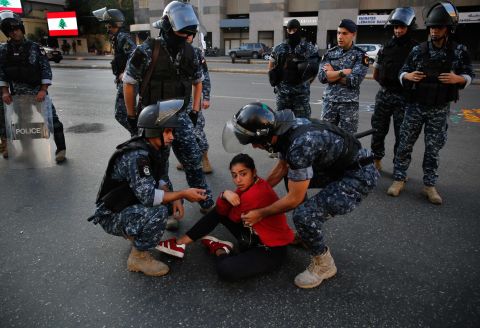 Police move an anti-government protester on Monday.