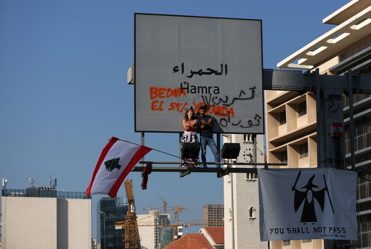Protesters perch on an overhead road sign in Beirut on November 4.