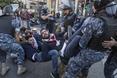 Riot police remove anti-government protesters who were occupying an intersection in Beirut, Lebanon, on Monday, November 4.