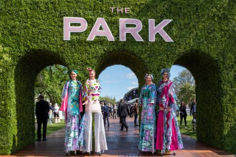 Models on stilts stand at the entrance of The Park, the lively, family-friendly area at Flemington Racecourse.
