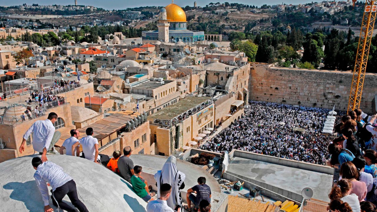 People gather at the Jewish quarter in the old city of Jerusalem as worshippers perform the annual Birkat Kohanim (Priestly Blessing) during the Sukkot holiday, or the feast of the Tabernacles, at the Western Wall (bottom) on October 16, 2019. - Thousands of Jews make the pilgrimage to Jerusalem during Sukkot, which commemorates the desert wanderings of the Israelites after their exodus from Egypt. (Photo by Menahem KAHANA / AFP) (Photo by MENAHEM KAHANA/AFP via Getty Images)
