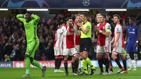 Ajax players react after the referee sends off two players and awards Chelsea a penalty.