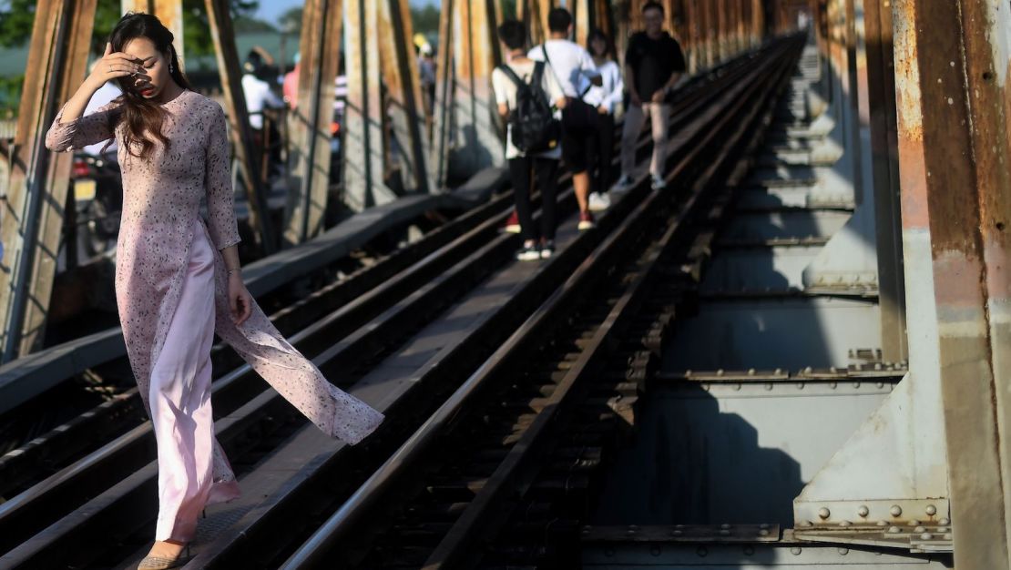 A Vietnamese woman walks on the century-old Long Bien bridge in Hanoi.