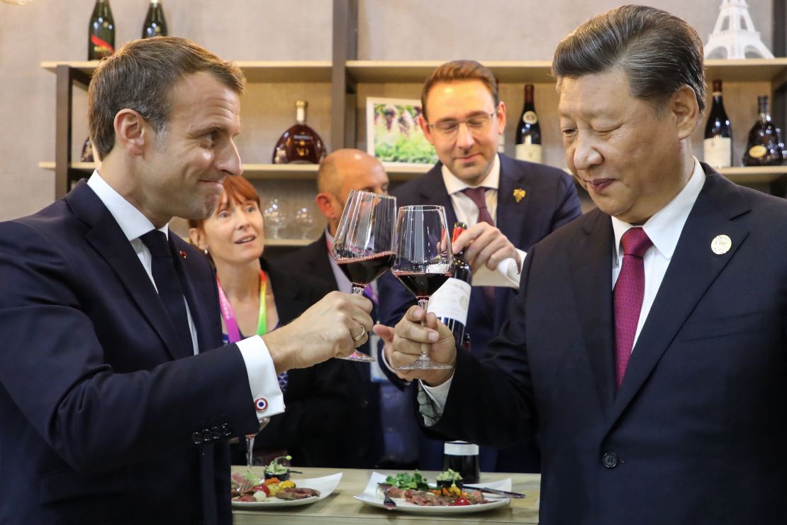 China's President Xi Jinping (right) and French President Emmanuel Macron (left) taste wine as they visit France's pavilion during the China International Import Expo in Shanghai in November 2019.