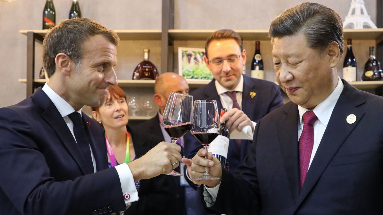 China's President Xi Jinping (right) and French President Emmanuel Macron (left) taste wine as they visit France's pavilion during the China International Import Expo in Shanghai in November 2019.