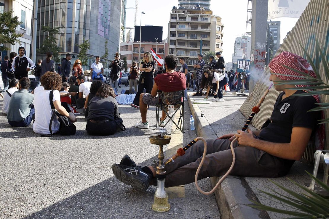An anti-government protester smokes a water pipe as others block a main highway in Beirut on November 4.