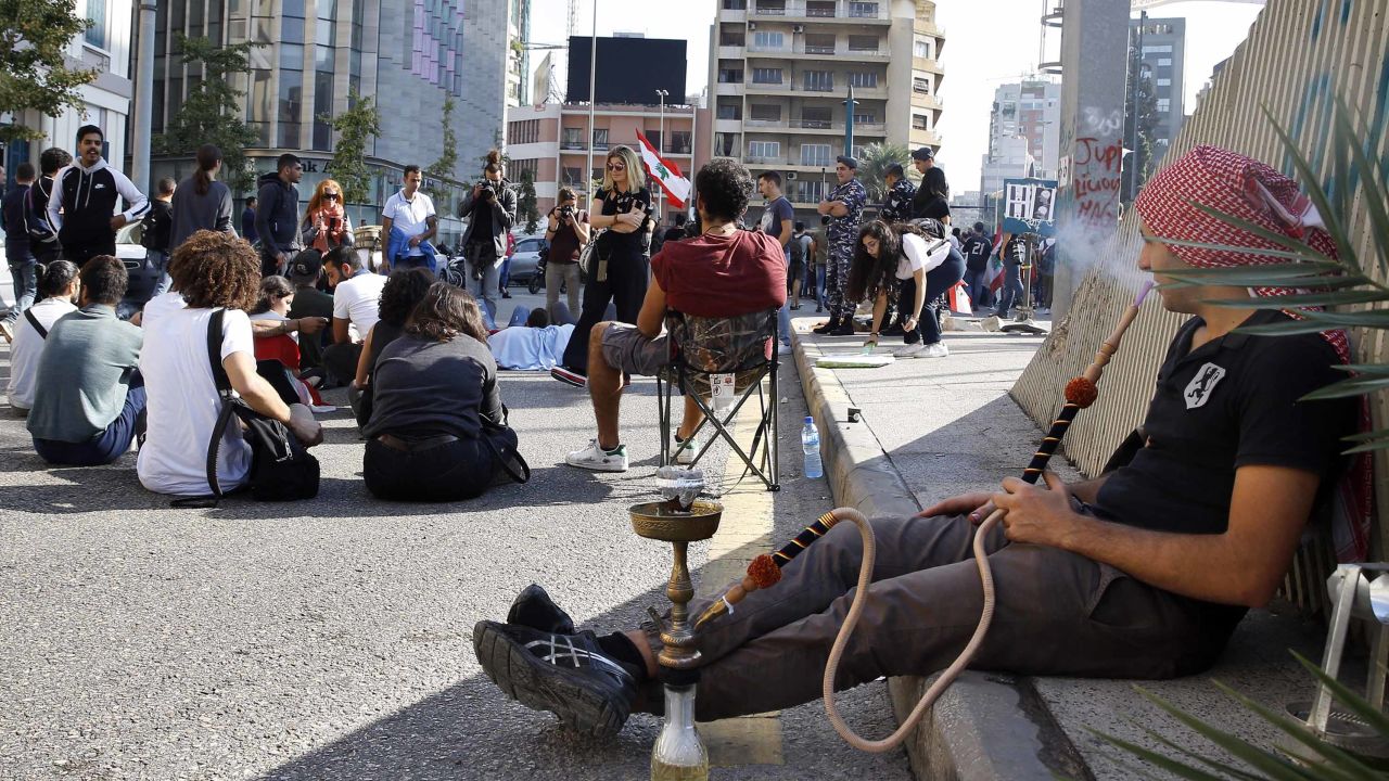 An anti-government protester smokes a water pipe as others block a main highway in Beirut on November 4.
