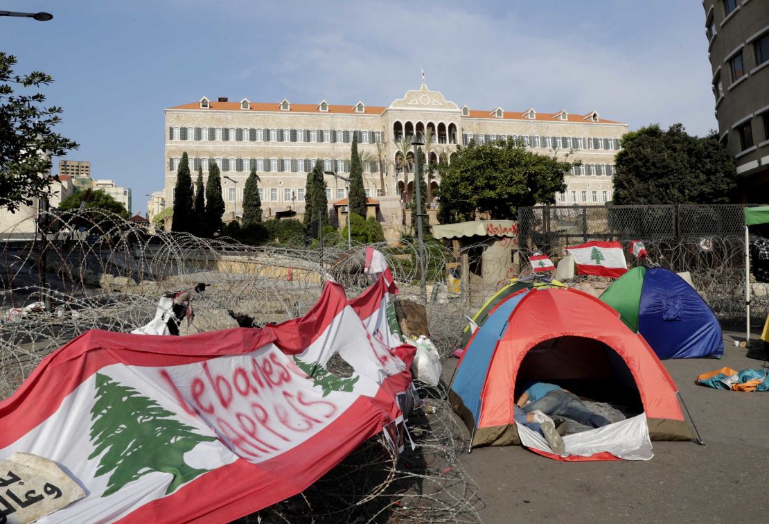 Lebanese protesters sleep in tents in front of the government headquarters, known as the Grand Serail building, in Beirut on October 25.