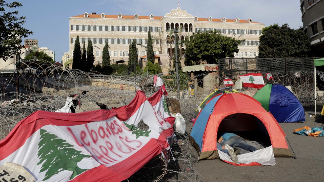 Lebanese protesters sleep in tents in front of the government headquarters, known as the Grand Serail building, in Beirut on October 25.