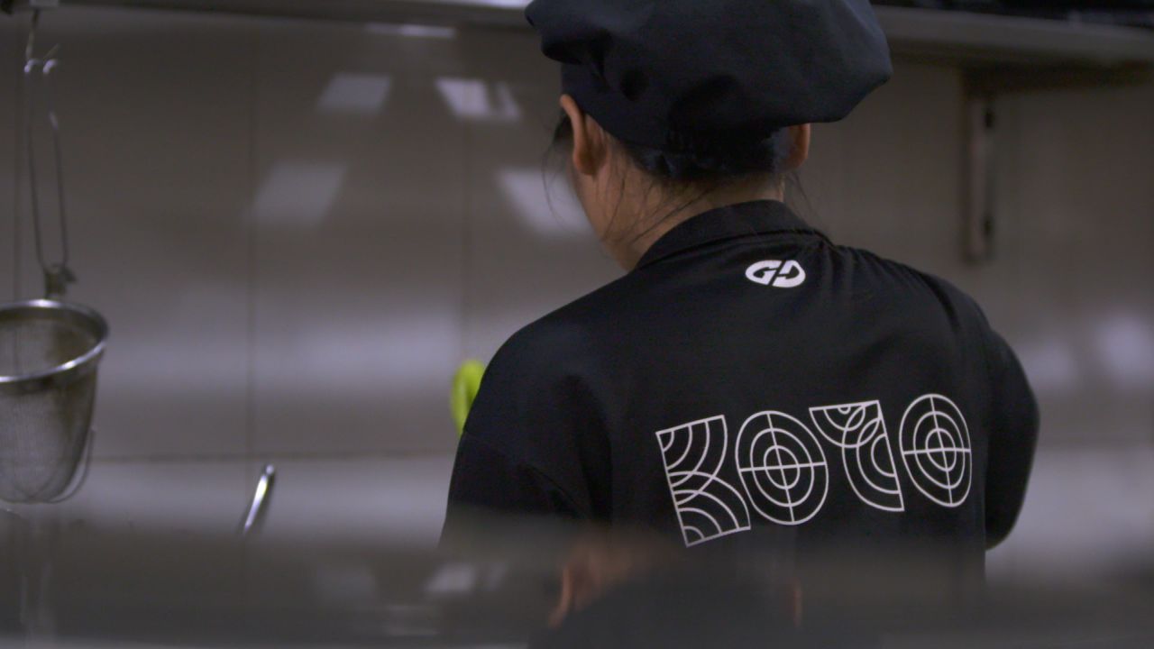 A KOTO student sports a branded black T-shirt while working.